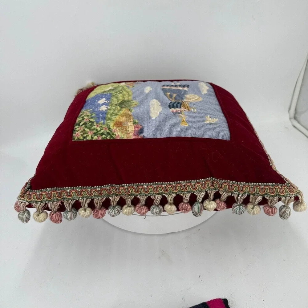 Needlepoint pillow featuring a folk art angel motif dark red velvet background